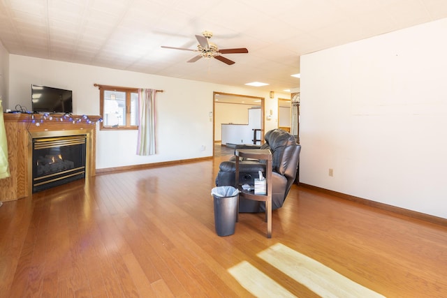 7868 Beech Ave, Russells Point, OH 43348 - living area featuring ceiling fan, baseboards, wood finished floors, and a glass covered fireplace