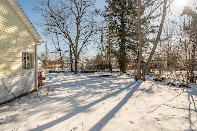 yard covered in snow with a trampoline