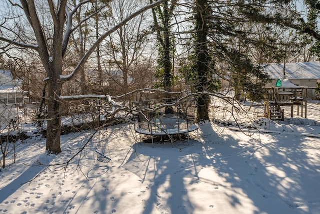 yard layered in snow with a trampoline