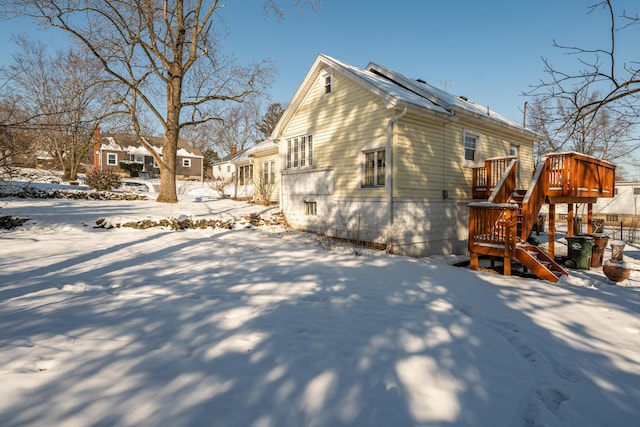 snow covered property with a wooden deck