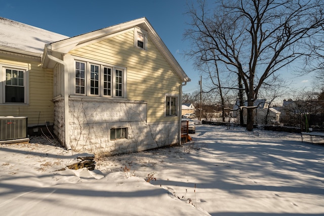 snow covered property featuring central air condition unit