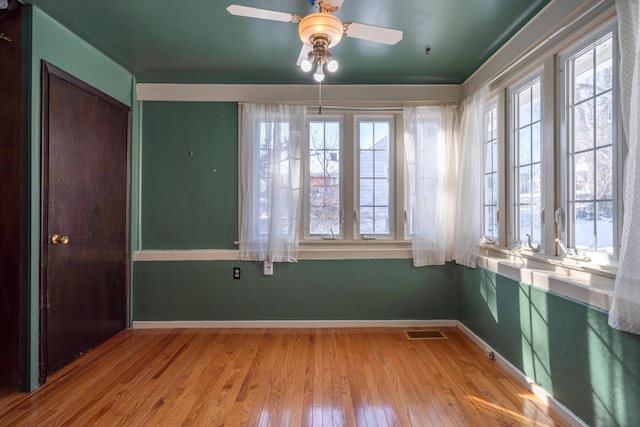 unfurnished room featuring a wealth of natural light, visible vents, and light wood-style floors