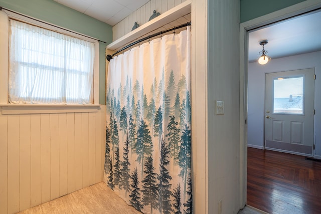 bathroom with wood walls and wood finished floors