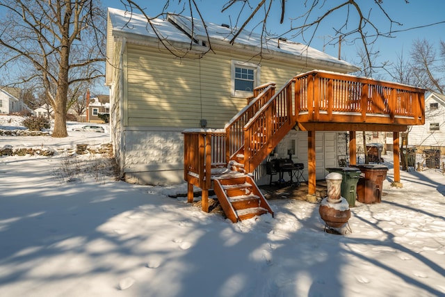 snow covered property featuring stairs and a deck