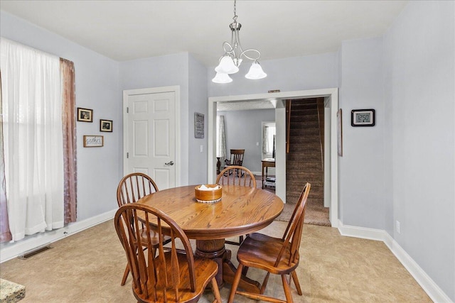 402 E Baird St, West Liberty, OH 43357 - dining space featuring light colored carpet, a chandelier, stairway, and healthy amount of natural light