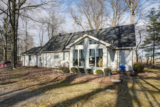 back of house with roof with shingles and a sunroom