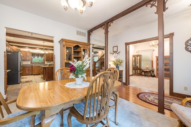 4602 State Route 273, Belle Center, OH 43310 - dining room with a chandelier, stairway, beamed ceiling, and light wood-style floors