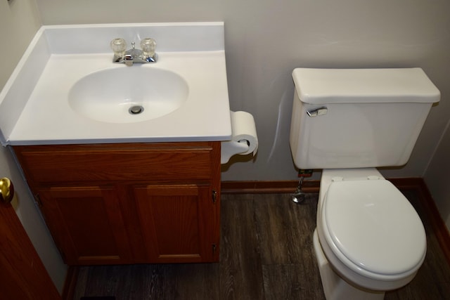 bathroom with toilet, wood finished floors, and vanity