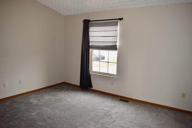 unfurnished room featuring a textured ceiling, carpet flooring, visible vents, and baseboards