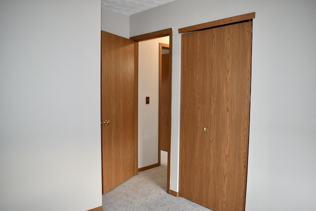 bedroom featuring light carpet, a closet, and baseboards