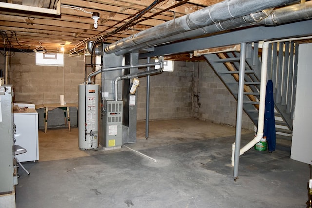 below grade area featuring heating unit, stairs, water heater, and washer / clothes dryer