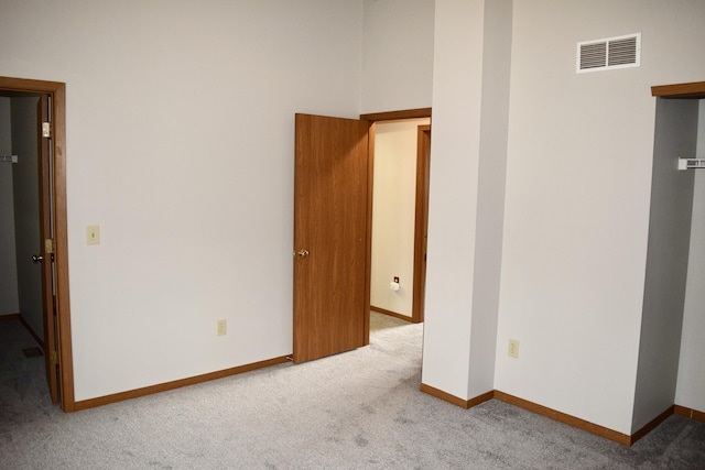 unfurnished room featuring visible vents, light carpet, and baseboards