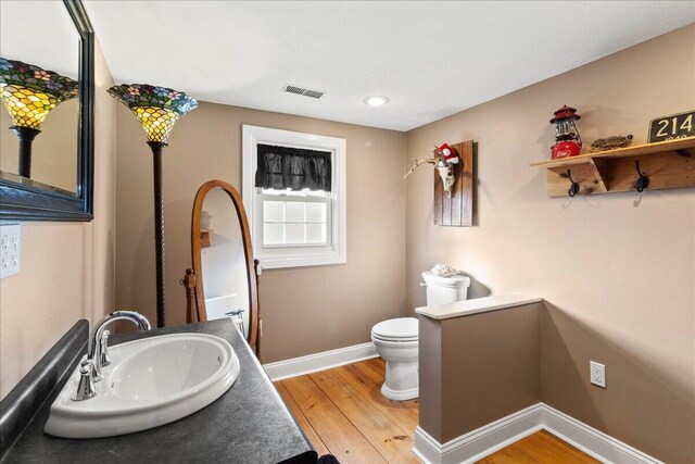 bathroom with vanity, hardwood / wood-style floors, and toilet