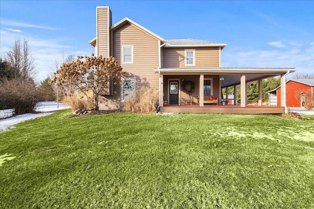 rear view of house featuring a yard and covered porch