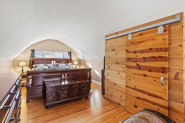 bedroom with vaulted ceiling and light hardwood / wood-style flooring