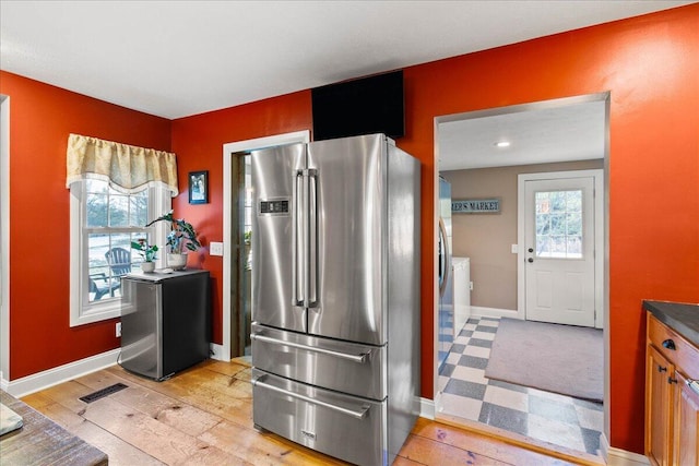 kitchen with high end fridge and light hardwood / wood-style floors