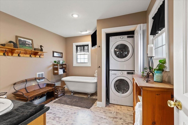 clothes washing area featuring stacked washer / drying machine