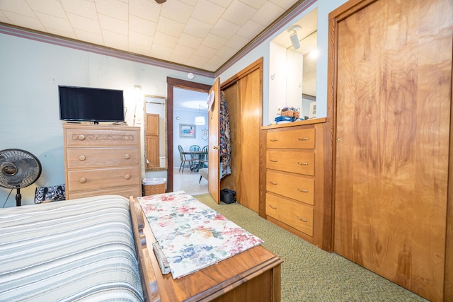 bedroom with ornamental molding, a closet, and light colored carpet