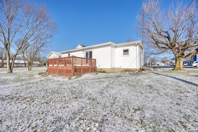 snow covered back of property featuring a wooden deck