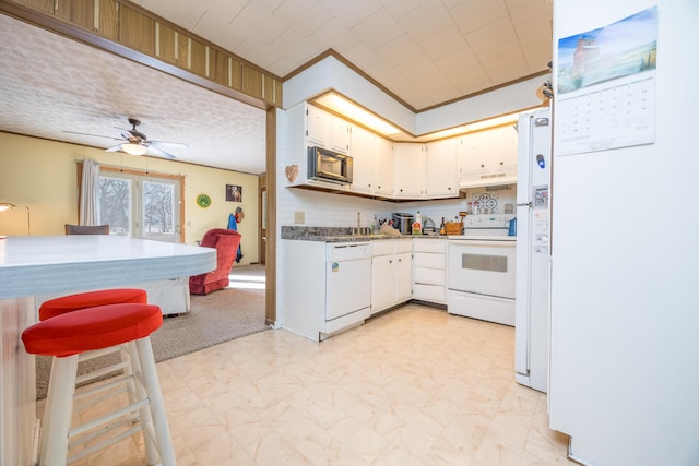 kitchen with ornamental molding, white cabinets, ceiling fan, white appliances, and under cabinet range hood