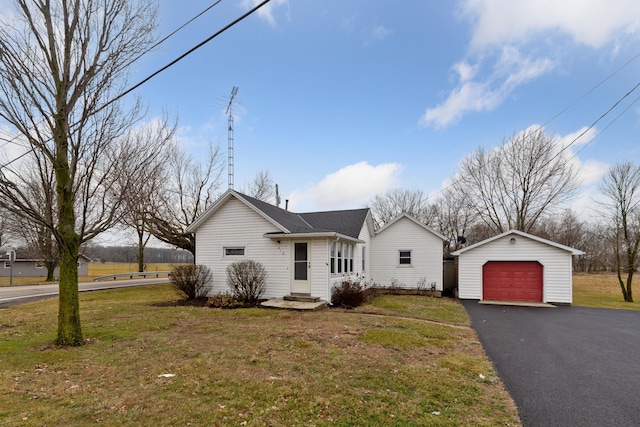 view of front of house featuring driveway, an outdoor structure, a detached garage, and a front yard