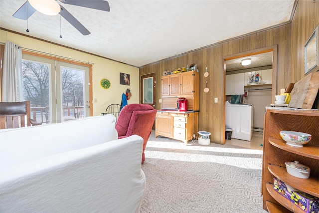 bedroom with access to exterior, wooden walls, washer / clothes dryer, and a ceiling fan