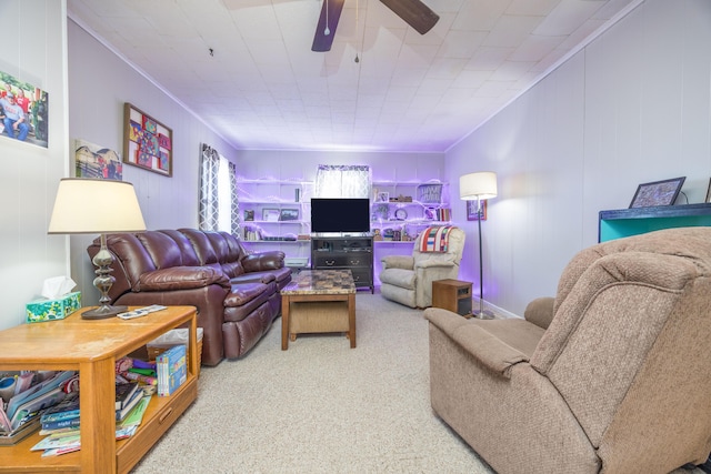 carpeted living room featuring a ceiling fan and crown molding