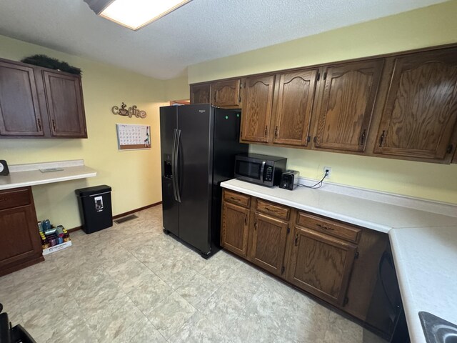 411 Middle St, Wapakoneta, OH 45895 - kitchen featuring stainless steel microwave, black fridge, light countertops, and dark brown cabinetry