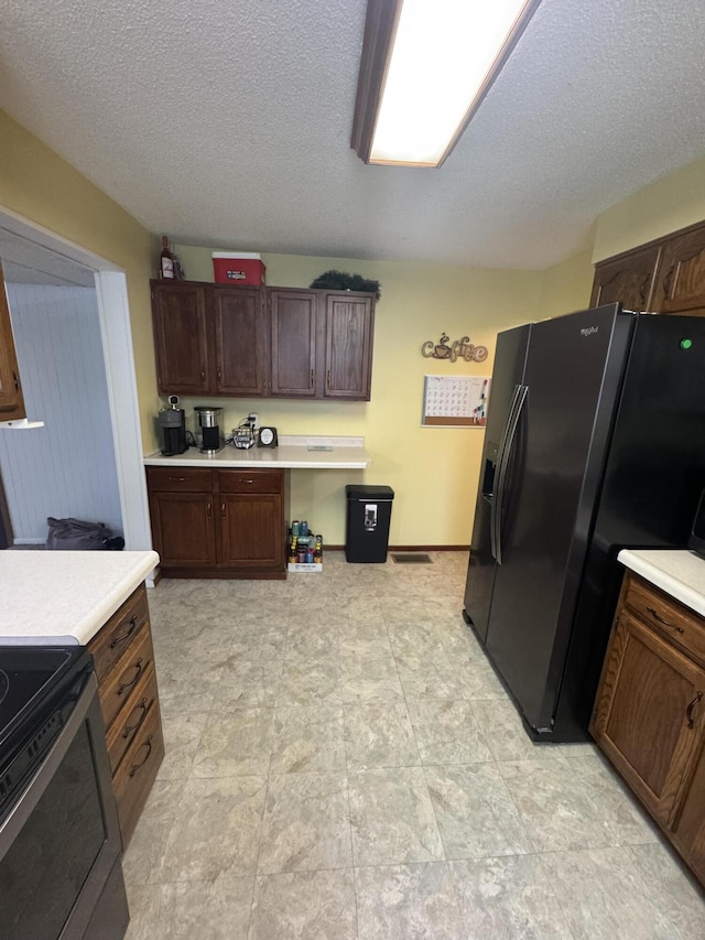 411 Middle St, Wapakoneta, OH 45895 - kitchen featuring black fridge with ice dispenser, light countertops, range with electric cooktop, a textured ceiling, and dark brown cabinets