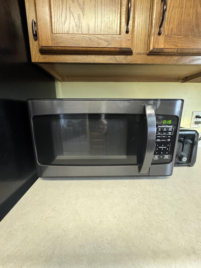 411 Middle St, Wapakoneta, OH 45895 - kitchen view of stainless steel microwave, brown cabinetry, and light countertops