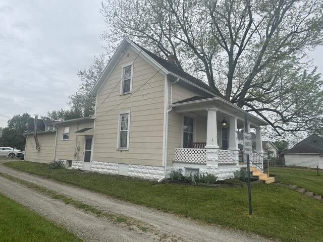 411 Middle St, Wapakoneta, OH 45895 - view of front facade with a porch, a front yard, and a chimney