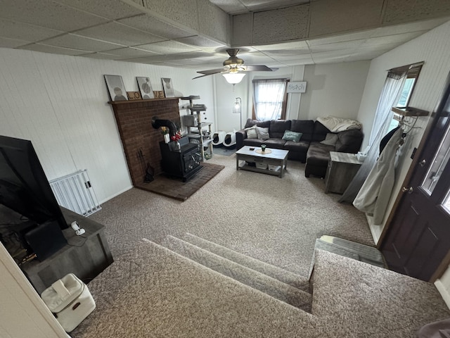 411 Middle St, Wapakoneta, OH 45895 - carpeted living area featuring a drop ceiling, a wood stove, and a ceiling fan