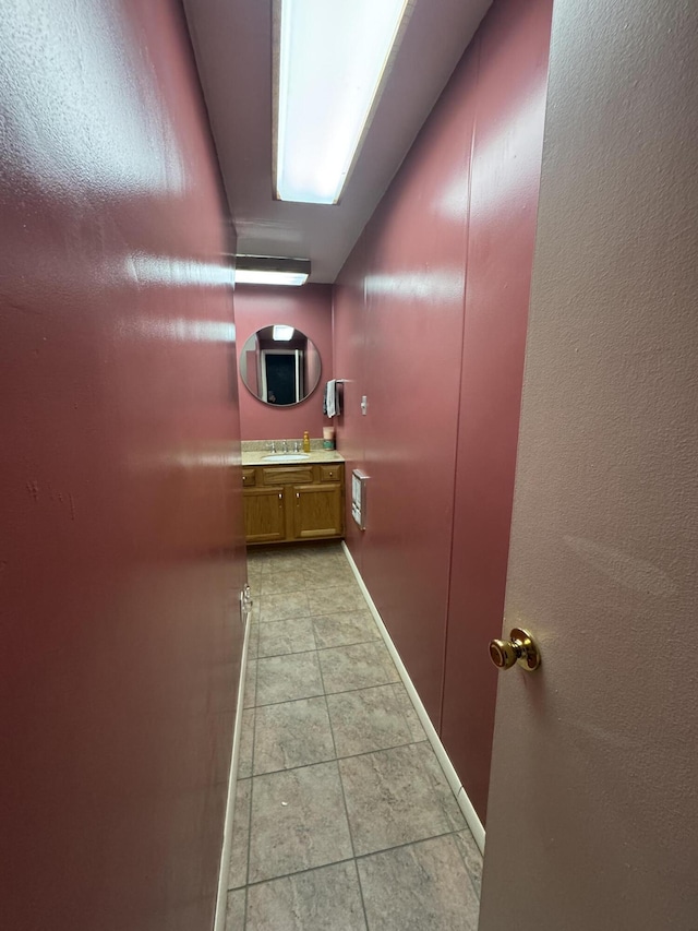 411 Middle St, Wapakoneta, OH 45895 - hallway with a sink, light tile patterned flooring, and baseboards