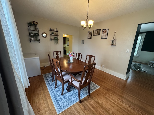 411 Middle St, Wapakoneta, OH 45895 - dining space with wood finished floors, a chandelier, baseboards, and a textured ceiling