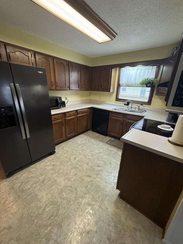 411 Middle St, Wapakoneta, OH 45895 - kitchen featuring black appliances, a sink, light countertops, and a textured ceiling