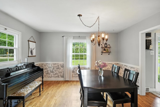 650 Swailes Rd, Troy, OH 45373 - dining area featuring a chandelier, light wood finished floors, and a wainscoted wall