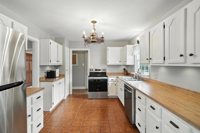 650 Swailes Rd, Troy, OH 45373 - kitchen with stainless steel appliances, a chandelier, white cabinetry, and light countertops