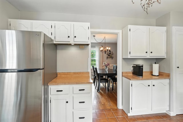 650 Swailes Rd, Troy, OH 45373 - kitchen with freestanding refrigerator, white cabinetry, a chandelier, and tile patterned floors