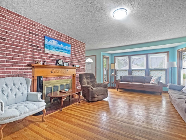 living area featuring a fireplace, wood-type flooring, and a textured ceiling
