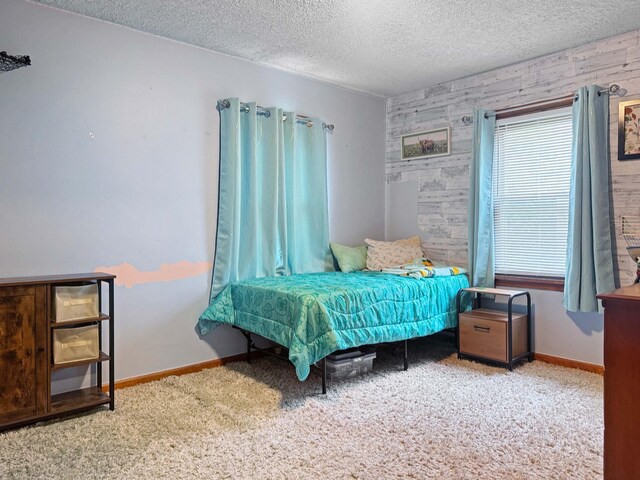 carpeted bedroom featuring baseboards and a textured ceiling