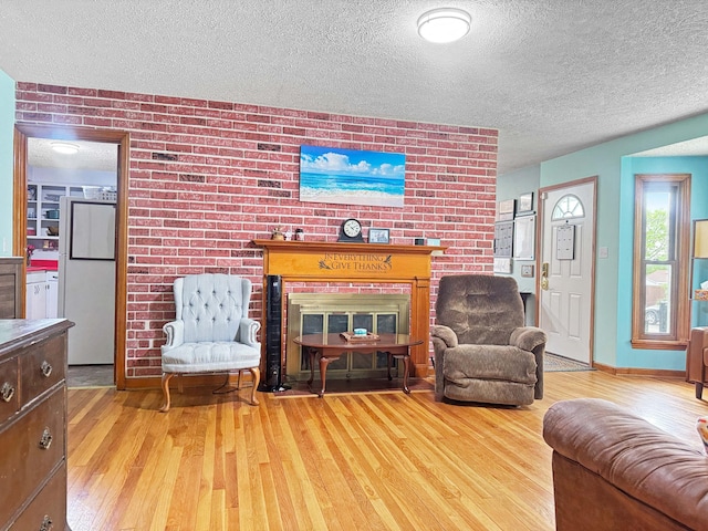 living room with baseboards, a textured ceiling, and wood finished floors