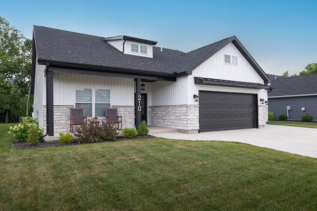 210 N Branch, Tipp City, OH 45371 - view of front of house featuring stone siding, a shingled roof, driveway, a front yard, and board and batten siding