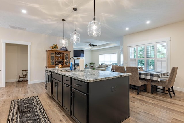 210 N Branch, Tipp City, OH 45371 - kitchen with ceiling fan, light wood finished floors, recessed lighting, light stone counters, and an island with sink