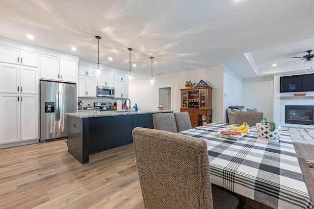 210 N Branch, Tipp City, OH 45371 - dining space featuring light wood finished floors, recessed lighting, ceiling fan, and a large fireplace