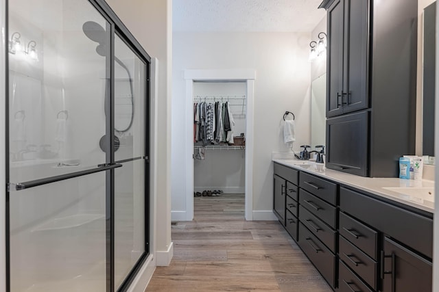 210 N Branch, Tipp City, OH 45371 - full bathroom with a shower stall, double vanity, wood finished floors, a spacious closet, and a textured ceiling