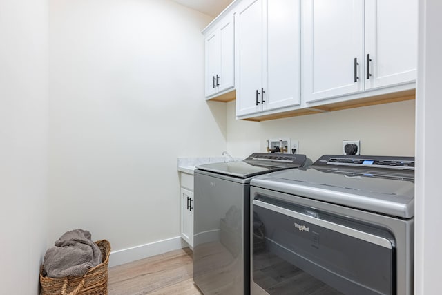 210 N Branch, Tipp City, OH 45371 - laundry room featuring washer and clothes dryer, cabinet space, and light wood-type flooring