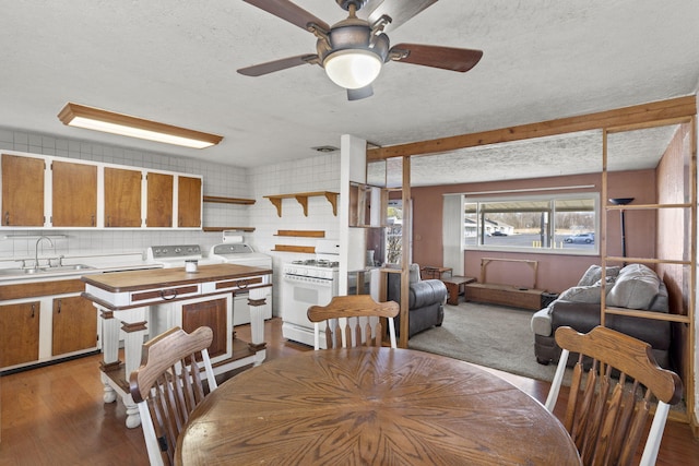 dining area featuring ceiling fan, sink, a textured ceiling, and light wood-type flooring