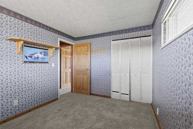 unfurnished bedroom with a closet, carpet floors, and a textured ceiling