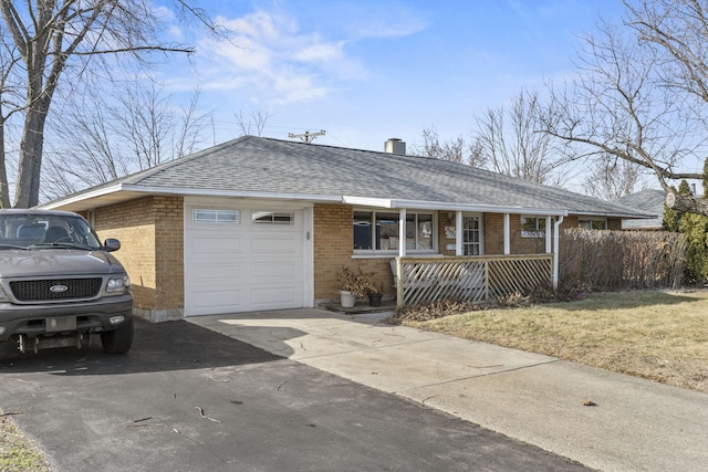 ranch-style home with a garage, a front yard, and covered porch