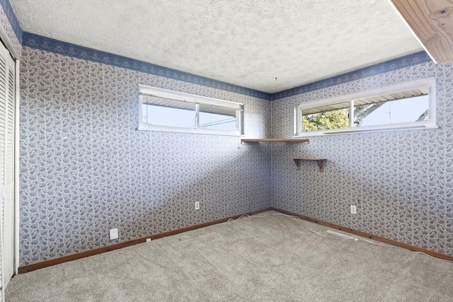 carpeted empty room with a textured ceiling